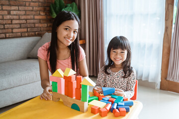 lovely sibling sister play with blocks while stay at home