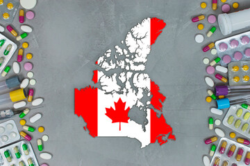 The Canada State began research for treatment and medicine to combat the pandemic outbreak disease coronavirus. Medicine, pills, needles, syringes and Canada map and flag on gray background.