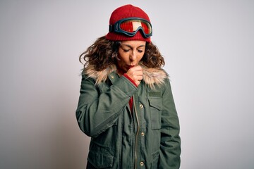Middle age skier woman wearing snow sportswear and ski goggles over white background feeling unwell and coughing as symptom for cold or bronchitis. Health care concept.