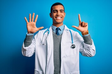 Handsome african american doctor man wearing coat and stethoscope over blue background showing and...
