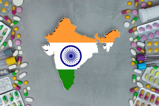 The India State began research for treatment and medicine to combat the pandemic outbreak disease coronavirus. Medicine, pills, needles, syringes and India map and flag on gray background.