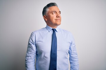 Middle age handsome grey-haired business man wearing elegant shirt and tie looking away to side with smile on face, natural expression. Laughing confident.
