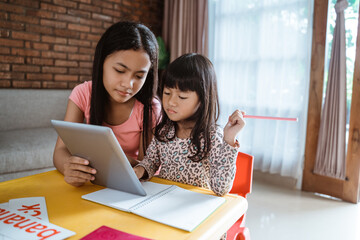 online learning with older sister at home using tablet pc