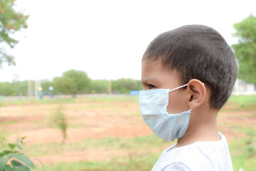 Portrait of Asian child boy wearing facial mask for protection from air pollution or virus epidemic . Health care concept.