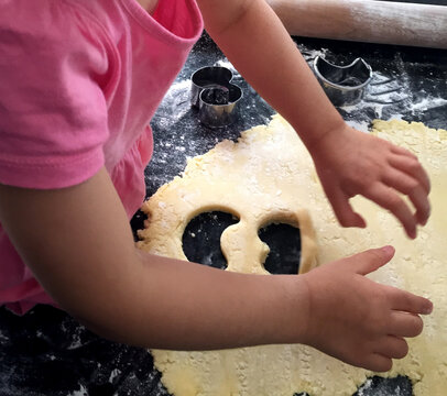 Niña aprendiendo a cocinar galletitas - Powered by Adobe