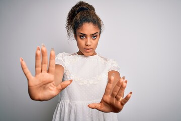 Young beautiful african american girl wearing casual t-shirt standing over white background doing...