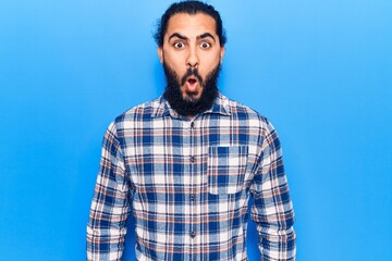 Fototapeta premium Young arab man wearing casual clothes scared and amazed with open mouth for surprise, disbelief face