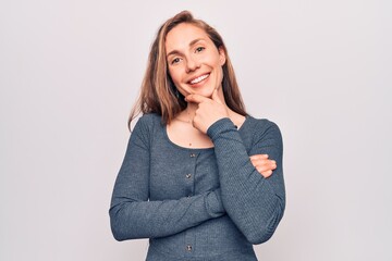 Young beautiful blonde woman standing over white isolated background smiling looking confident at the camera with crossed arms and hand on chin. thinking positive.