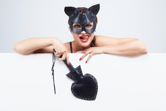 beautiful girl in a cat mask. indicates the free space for the text. white background