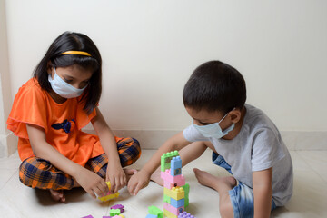kids are playing  indoor games with wearing mask during covid 19 pandemic