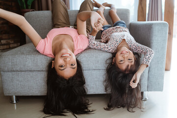 sister tickle each other playing together at home
