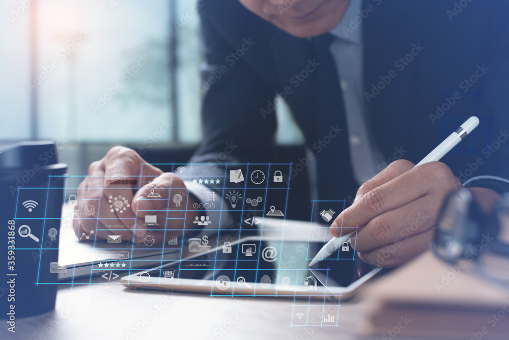 Poster businessman working on digital tablet and laptop in office with computer dashboard on virtual screen