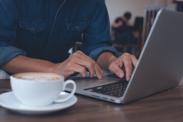 Fototapeta premium Casual business man freelancer online working on laptop computer in coffee shop coworking space