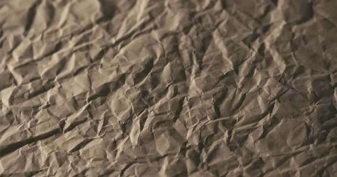 4K brown crumpled craft paper texture background, low poly mountains rotating slowly in macro