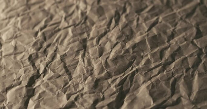 4K brown crumpled craft paper texture background, low poly mountains rotating slowly in macro