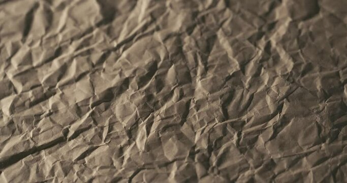 4K brown crumpled craft paper texture background, low poly mountains rotating slowly in macro