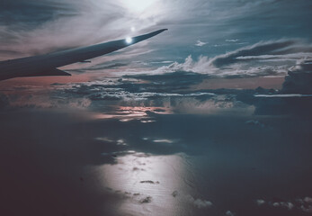 Fototapeta na wymiar Sunrise above clouds from window of an aircraft
