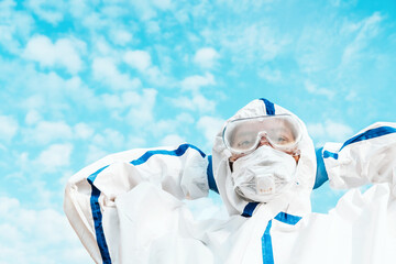 Man wearing protective COVID costume, mask, respirator and gloves. Doctor stay and looking forward...