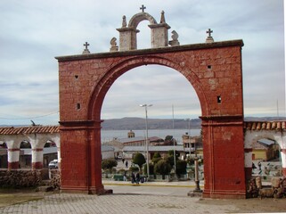 Arch of the Colonial church Nuestra Señora de la Asuncion (andean baroque) with view to the Lake Titicaca in Chucuito, Peru
