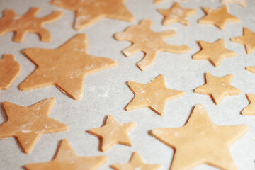 Star-shaped gingerbread cookie with on parchment. Christmas dessert. The process of baking cookies. Gingerbread dough.