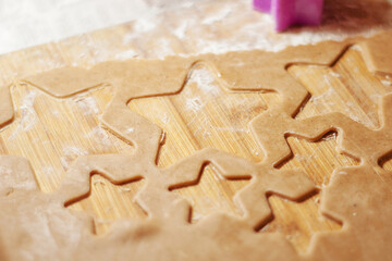 Star shaped gingerbread cookie on a wooden board. Christmas dessert. The process of baking cookies. Gingerbread dough.