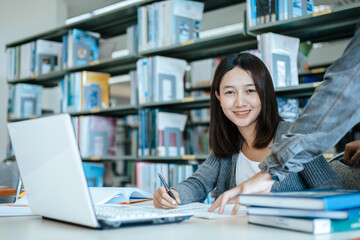 Students studying in the library with laptop at the university. Education concept.