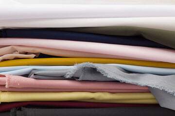 Multicolored fabrics folded in a stack top view on a white background. Multi-colored textile	
