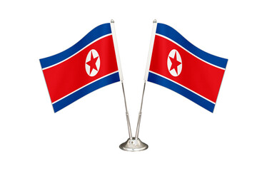 North Korea table flag isolated on white ground. Two flag poles with flags and North Korea flag on the table.