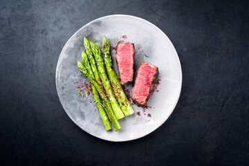 Gegrilltes dry aged Wagyu Roastbeef Steak vom Rind mit grünen Spargel und Kräuter als Draufsicht...