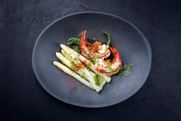 Traditionelle gegrillte Langustenschwänze aufgeschnitten und angeboten mit weißen Spargel und...