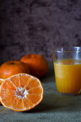 fresh oranges and fresh cold orange juice in the glass