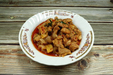 Fried spicy chopped streaky pork with chilly paste and local sauce on the plate. Famous traditional hot and spicy menu in Asia restaurant. 