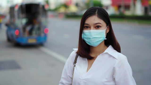 young woman in city street and wearing face mask protective for spreading of coronavirus(covid-19) pandemic, new normal concept