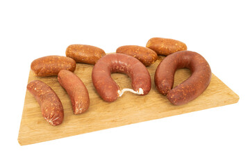 Presentation of sausage salami and bacon on a cutting board on a white background.
