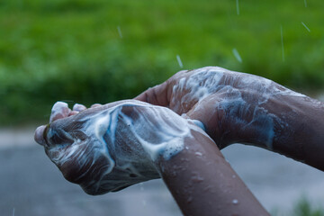 The boy who washes his hands with soap when it rains.  Against the background of green grass.