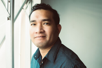 A close up portrait of young happy cheerful young man in office. young cool trendy man looking at...