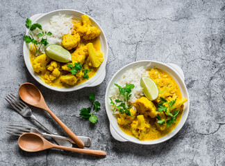 Indian food - vegetarian cauliflower curry with rice, cilantro, lime on grey background, top view - obrazy, fototapety, plakaty