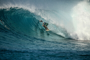 Surfer on perfect blue wave, in the barrel, clean water, Indian Ocean