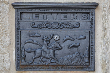Vintage metal letter box with ornate design of a rider on a horse painted in black color