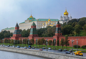 Fototapeta premium The Kremlin wall, tower and domes of cathedrals blurred in a winter snow storm with snowflakes in the air, Moscow Russia