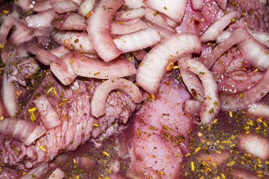 Turkey meat cut into pieces and marinated in red wine with onions and spices. Close-up, surface texture. - Powered by Adobe