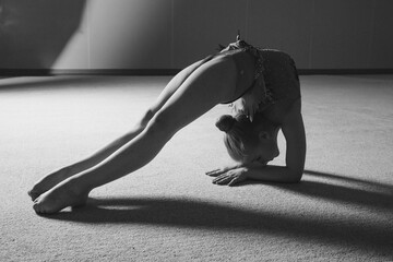 A girl in a tracksuit does a stretch. Gymnast goes in for sports. Healthy lifestyle concept, sports uniforms, world Cup, gym, specialized clothing, uniforms
