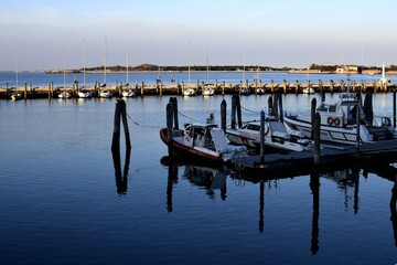 boats reflected in the water at the port of chioggia