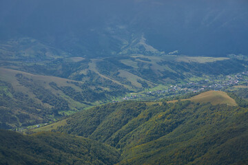 Mountain landscape in the autumn season. Beautiful natural yellow green orange paint nature. Lightly foggy day in the hills of the mountains.