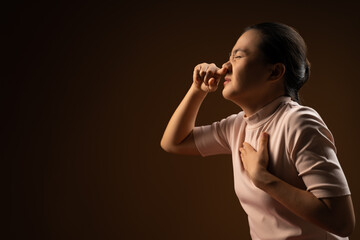 Asian woman was sick with sore throat standing isolated on beige background.