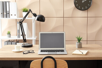 Modern workplace with laptop in room