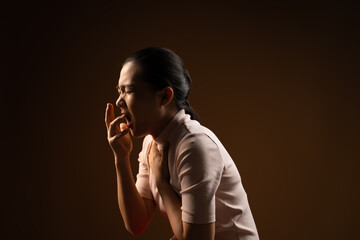 Asian woman was sick with sore throat standing isolated on beige background.