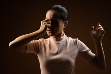Fototapeta premium Asian woman was sick with eyes pain standing isolated on beige background.