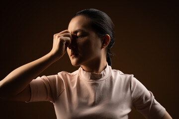 Asian woman was sick with eyes pain standing isolated on beige background.