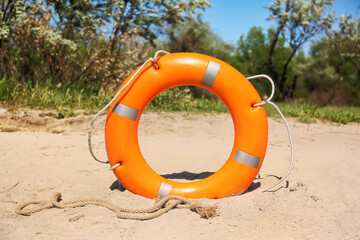 Bright lifebuoy ring on beach